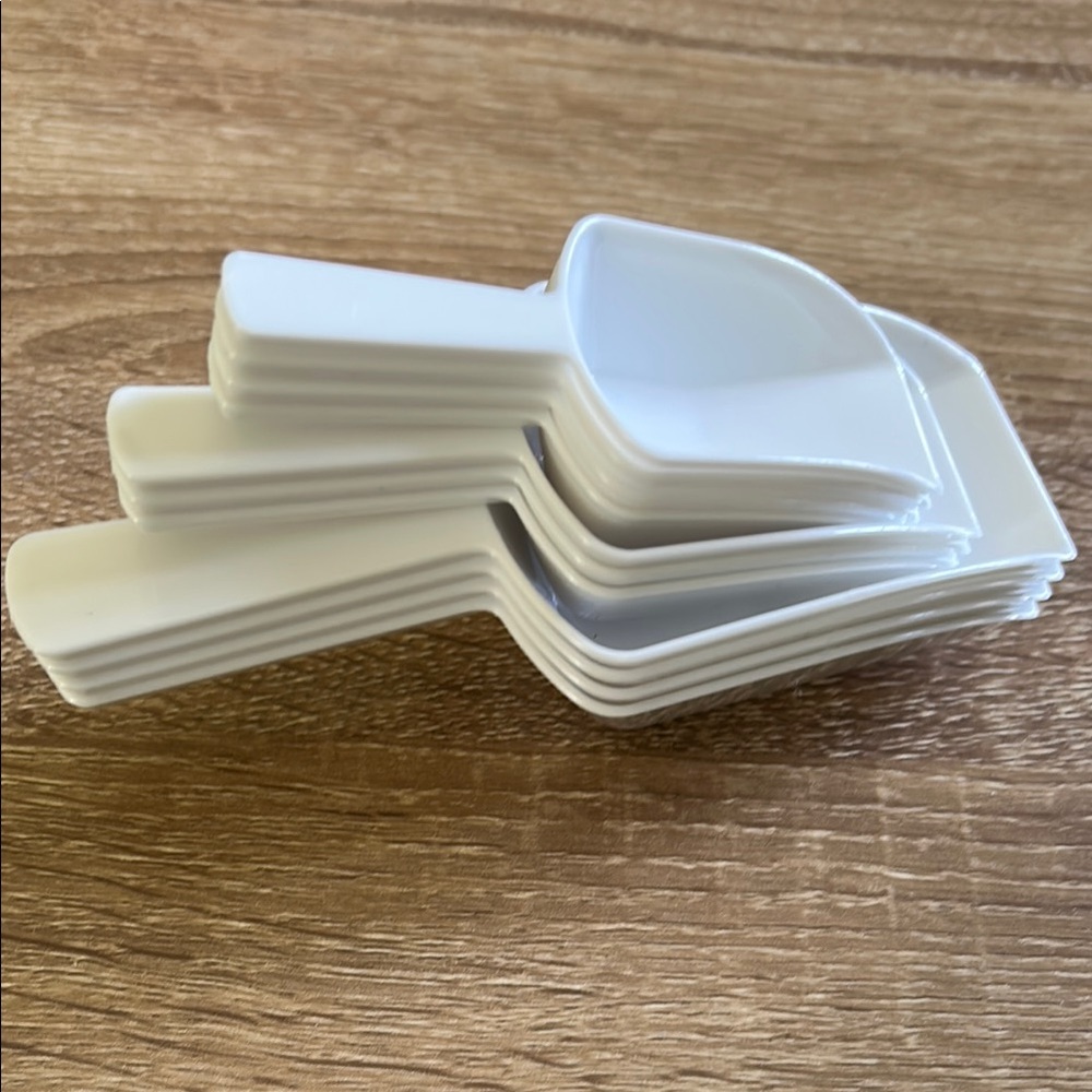 Stack of White Plastic Scoops - 11 pieces